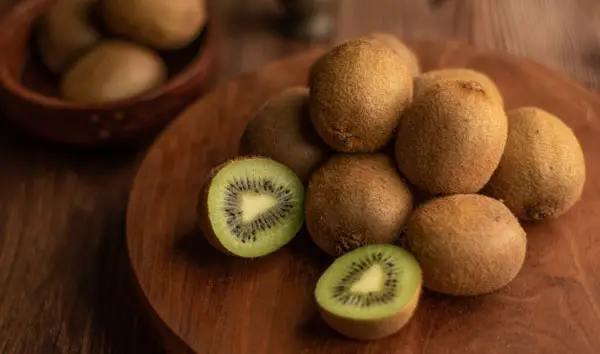 A pile of exotic kiwi fruit on a chopping bord
